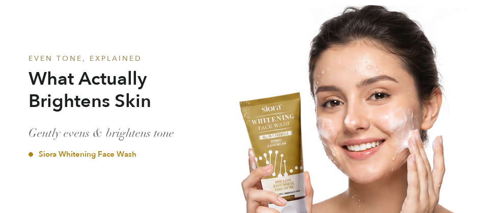 Smiling model washing her face with foam and water, holding a Siora Whitening Face Wash tube