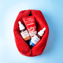 Red pouch with skincare products including face wash, serum, and toner on a light blue background